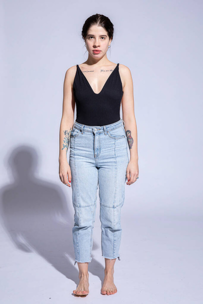Young woman in jeans isolated on grey - Photo, Image