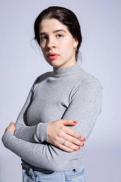 White girl in roll neck with folded arms isolated on grey - Valokuva, kuva
