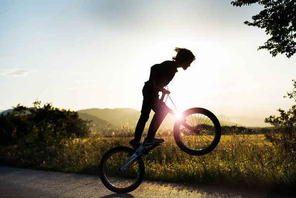 persona saltando a traves del sol con la bicicleta - Valokuva, kuva