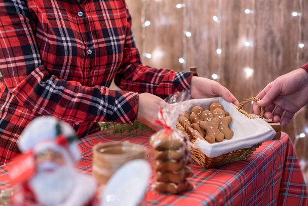 Muž zákazník kupující vánoční muž perník, sladkosti v pekárně ležící v slaměném koši na pultu. Odveďte.. - Fotografie, Obrázek
