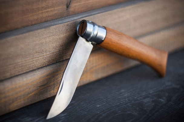 couteau pliant avec poignée en bois sur fond en bois - Photo, image