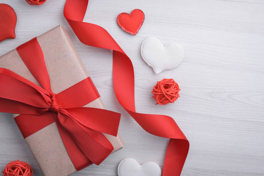 Fondo para la tarjeta de felicitación del día de San Valentín. Concepto del día de San Valentín. Cintas de regalo rojas, regalos, corazones sobre un fondo de madera. Vista superior. - Foto, Imagen