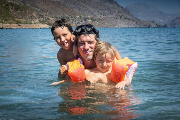 Mutlu baba ve oğul denizde yüzerken eğleniyorlar. - Fotoğraf, Görsel