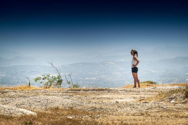 Vista laterale della giovane donna che guarda la catena montuosa - Foto, immagini