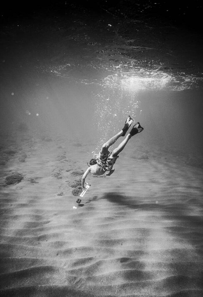 Giovane ragazzo che fa snorkeling sott'acqua - Foto, immagini