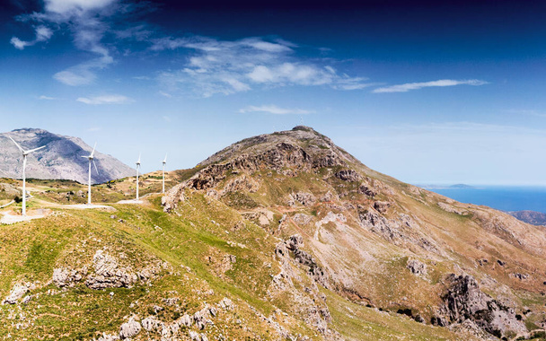 Ветряные мельницы на скалистой горе против неба - Фото, изображение