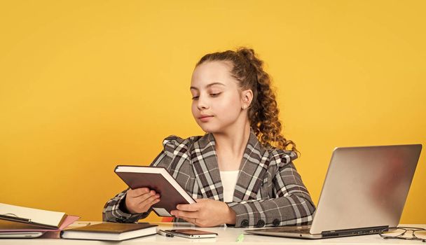 lets read book. schoolgirl has online homework. back to school. time to study. small girl in office. little businesswoman. happy childhood. kid with curly hair wear jacket. work on laptop - Photo, image