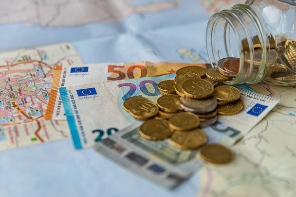 Економія, монети і банкноти на дерев'яній поверхні і в прозорій банці. Гроші, збережені для подорожей
. - Фото, зображення