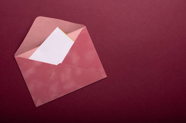 Pink envelope on a burgundy background - Fotoğraf, Görsel