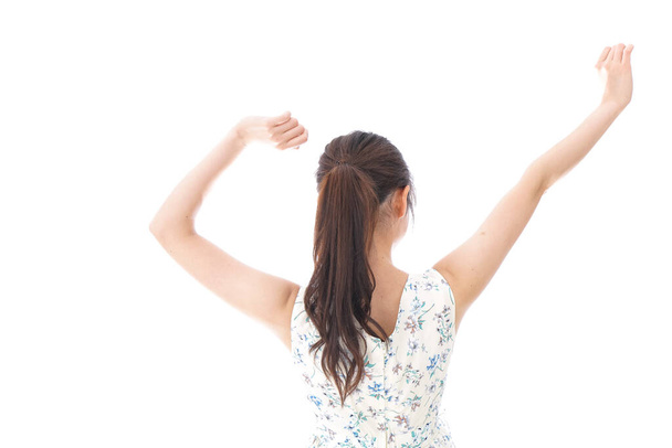 Молодая женщина поднимает руки на белом фоне  - Фото, изображение