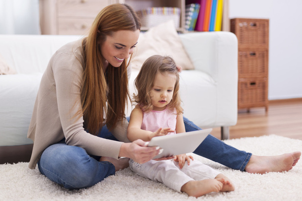 mother helping her daughter with digital tablet - Photo, Image