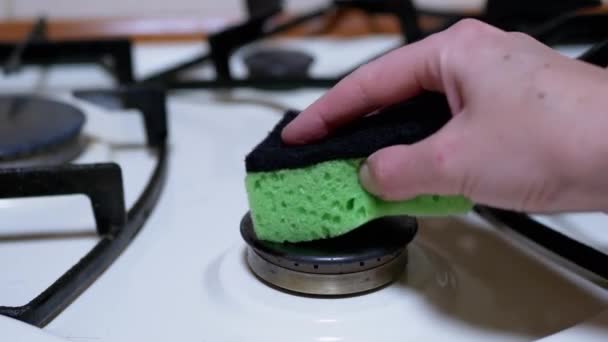 Γυναικείο Χέρι ένα μαντηλάκια και καθαρίζει, πλένει την κουζίνα αερίου, καυστήρες με ένα πράσινο σφουγγάρι - Πλάνα, βίντεο