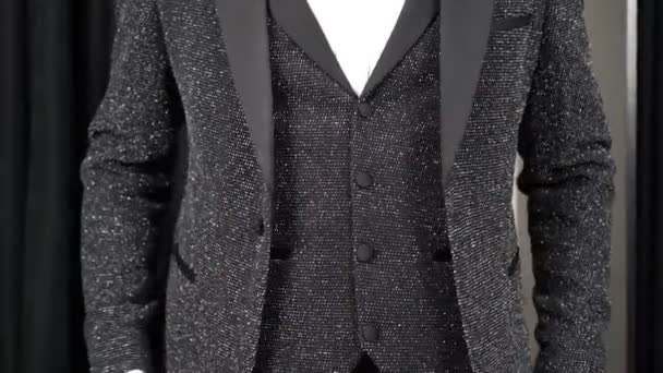 άνθρωπος δοκιμάζει σε ένα όμορφο κομψό μαύρο κλασικό κοστούμι - Πλάνα, βίντεο
