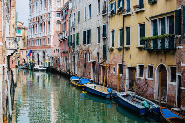 Канал між старими будинками і синіми човнами в місті Венеція. Італія. - Фото, зображення