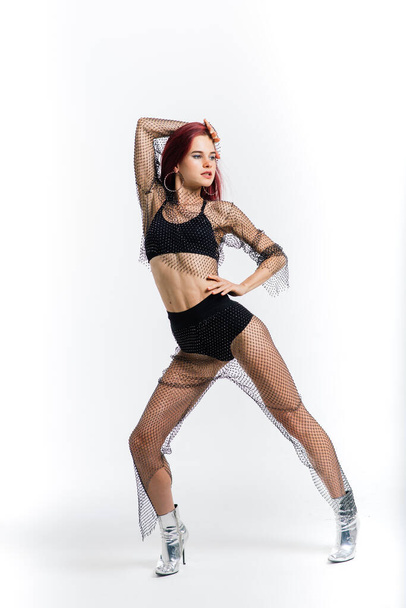 Σέξι κοκκινομάλλα χορεύτρια που δείχνει το όμορφο σώμα της - Φωτογραφία, εικόνα