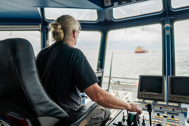 Fedélzeti tiszt parancsnoka hajó vagy hajó hídon navigációs szolgálat közben a tengeren - Fotó, kép
