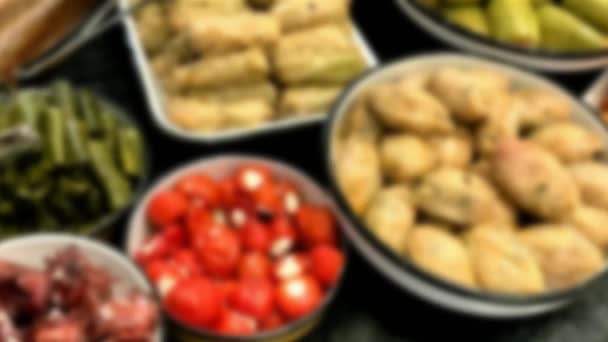 Diversi snack orientali sul bancone del negozio: foglie di uva ripiene e zucchine. Vista offuscata. HD.  - Filmati, video