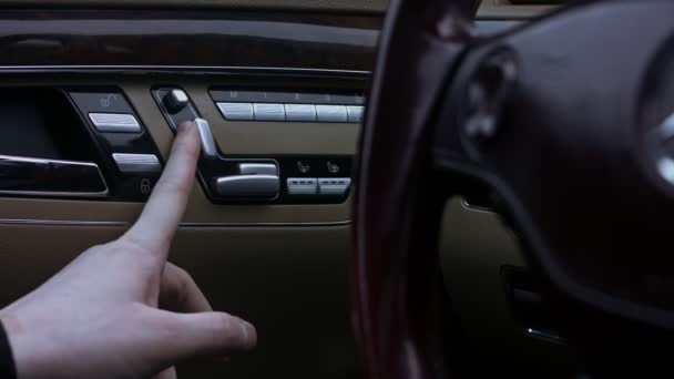Widok z bliska na elektryczną regulację siedzenia z przyciskami sterującymi, wewnątrz samochodu. Wewnętrzny przycisk regulacji fotela w drzwiach. Wideo 4K - Materiał filmowy, wideo