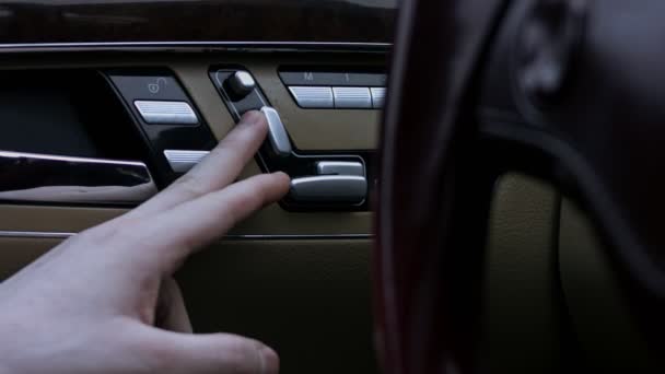 Een close-up zicht op elektrische stoelverstelling met bedieningsknoppen, in een auto. Binnendeur stoel verstellen knop schakelaar. 4K-video - Video