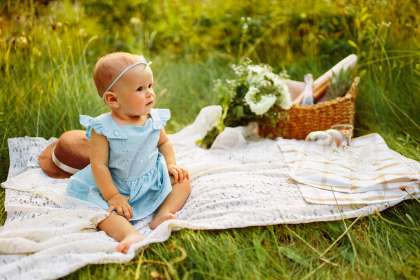 cute little girl sitting on the grass in the park - Fotó, kép