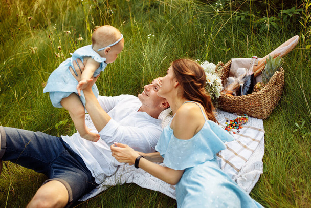 Happy young family with baby girl  on picnic in the park - Fotoğraf, Görsel