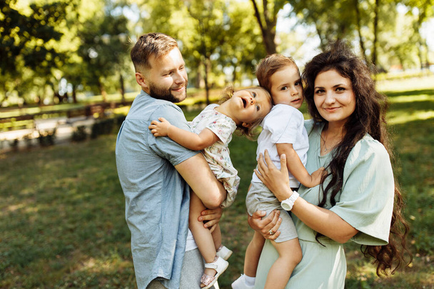 Happy young family with children relaxing  in the park - Fotoğraf, Görsel