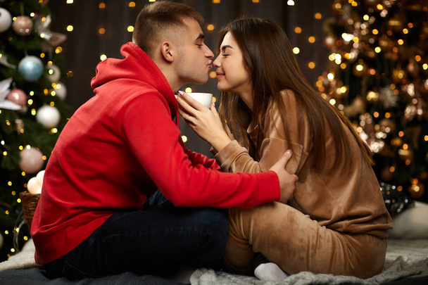 loving couple kissing on the Christmas tree backgroud - Φωτογραφία, εικόνα