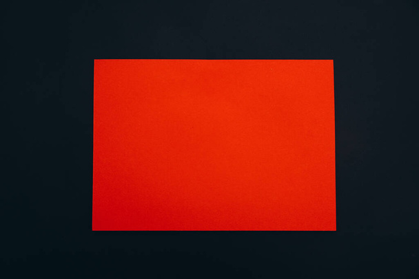 red paper sheet on black background - Foto, Imagem