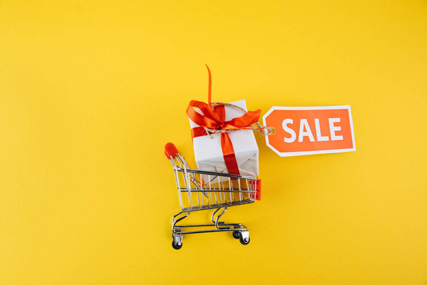 shopping cart and gift with sale label - Photo, Image