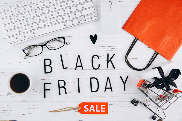 Black Friday board on a white wooden table, top view - 写真・画像
