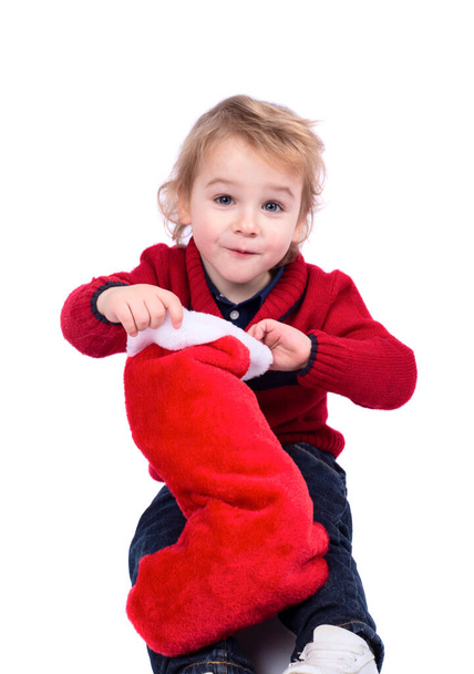 Little boy with his Christmas stocking gift isolated on white background - Foto, Imagen