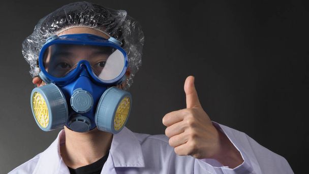 Asian woman doctor in a chemical protective medical mask and protective goggles. Doctor uniform clothing and half mask replaceable particulate filter respirator. Women scientist safety mask - Photo, Image