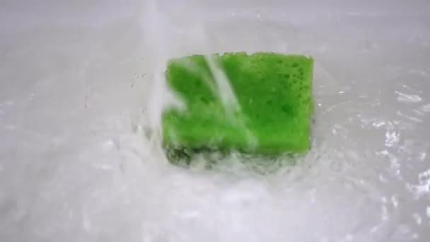 Drain Hole in Sink is Clogged Green Sponge. Bubbling Water Pours Into White Sink - Footage, Video