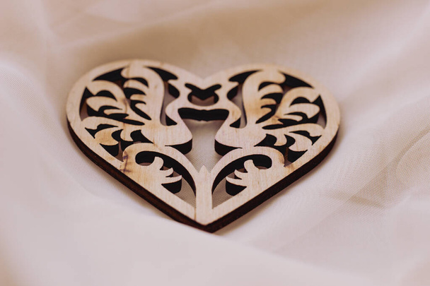 Valentijnsdag achtergrond met houten mooi hart en witte bloemen op lichte achtergrond - Foto, afbeelding