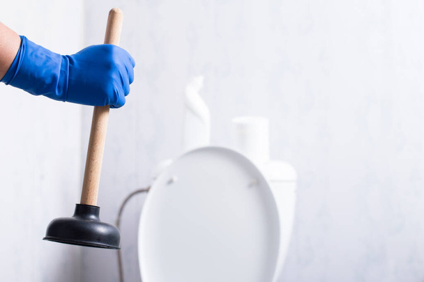 Рука собирается чистить туалет застрял с присоской чашки дома. - Фото, изображение