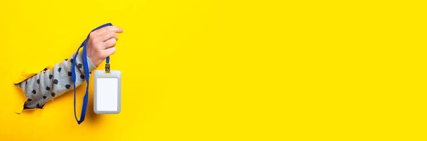Main de femme tient un badge de nom vierge sur un fond jaune. Bannière - Photo, image
