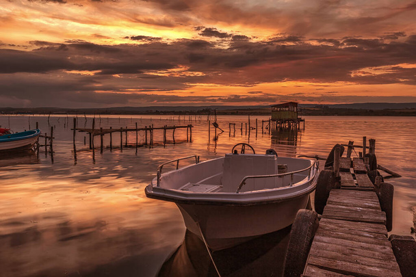 mood and tranquility at a lake shore with a boat at a wooden pier - Photo, Image