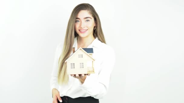 Young woman holding a house in her hands. Isolated on white. architecture, building, construction, real estate and property concept    - Materiaali, video