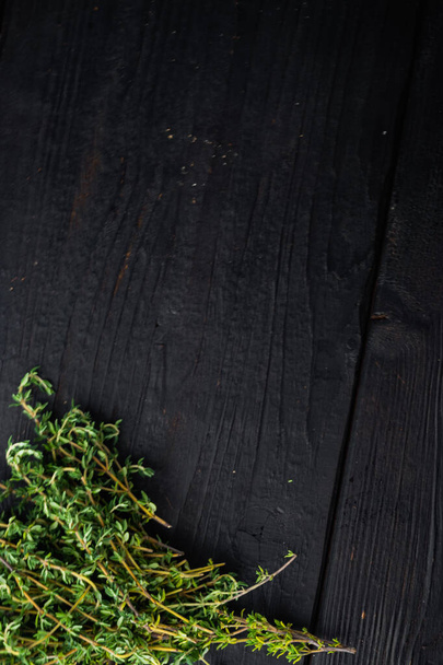 Thyme green fresh bunch, on black wooden table, top view with copy space for text - 写真・画像
