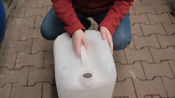Chica elige gran recipiente de plástico para el combustible en la tienda - Foto, Imagen