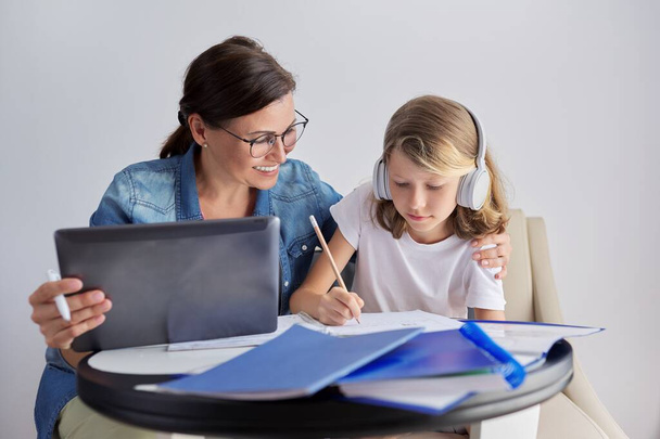 Mom and daughter student learning school lessons together at home - Photo, Image