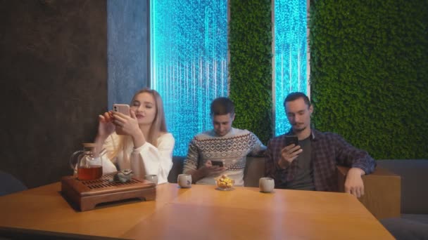 Trois les meilleurs amis passent du temps ensemble dans un café à thé chinois traditionnel, ils utilisent des téléphones - Séquence, vidéo