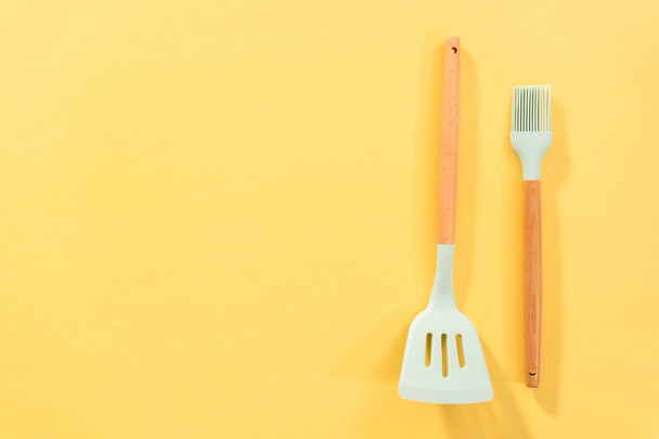 Flat lay. Silicone cooking utensils with wooden handle. - Fotografie, Obrázek