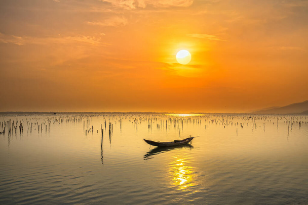 Vissersboot in de grote lagune bij zonsondergang hemel. Dit is het belangrijkste vervoermiddel om vis van vissers in centraal Vietnam te vangen. - Foto, afbeelding