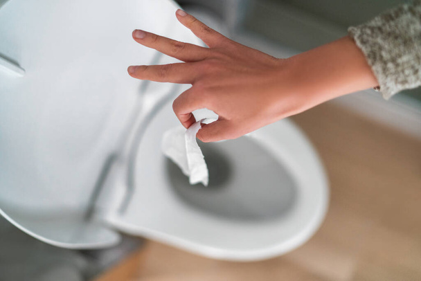 Flushing down disinfectant wipes as toilet paper shortage alternative during panic buying coronavirus outbreark causing home toilets to clog - Photo, image