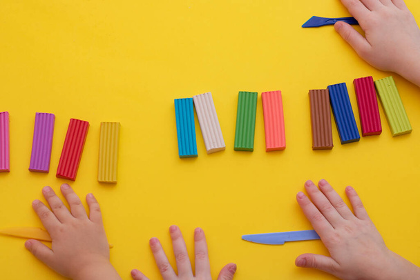 Kinderhände mit buntem Ton, Knetmasse. Kunsttherapiekonzept - Foto, Bild