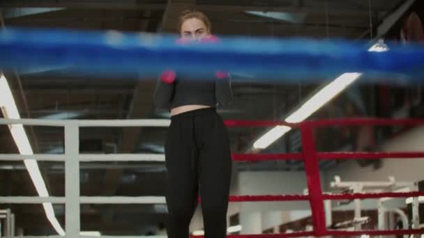 Una giovane donna con i capelli lunghi che sta per allenare la sua boxe ombra - Filmati, video