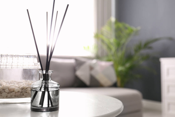 Aromatic reed air freshener on white table in room. Space for text - Foto, afbeelding