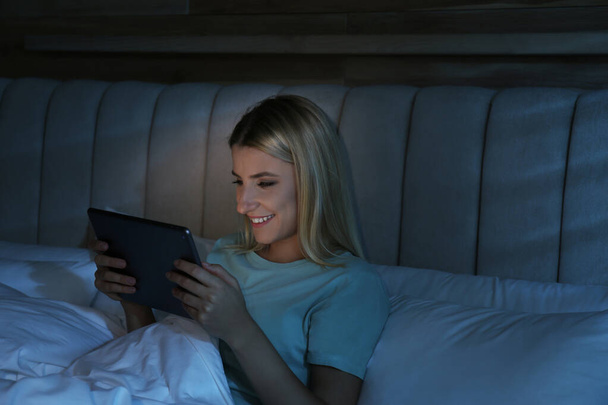 Young woman using tablet in bed at night. Sleeping disorder problem - Foto, Imagem