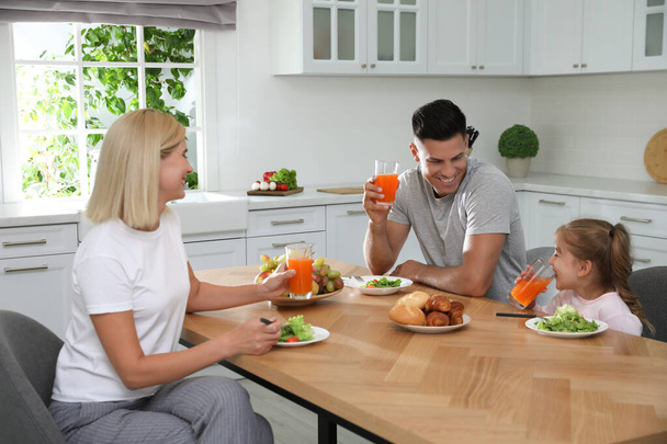 Happy family having breakfast together at table in modern kitchen - Фото, зображення